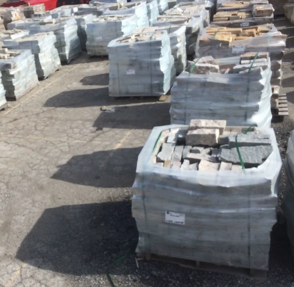 Rows of shrink-wrapped natural stone pallets in the Krooswyk yard